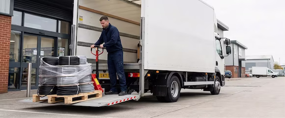 A 7.5T lorry equipped with a tail-lift delivering electrical supplies to a trade counter in Romford, UK
